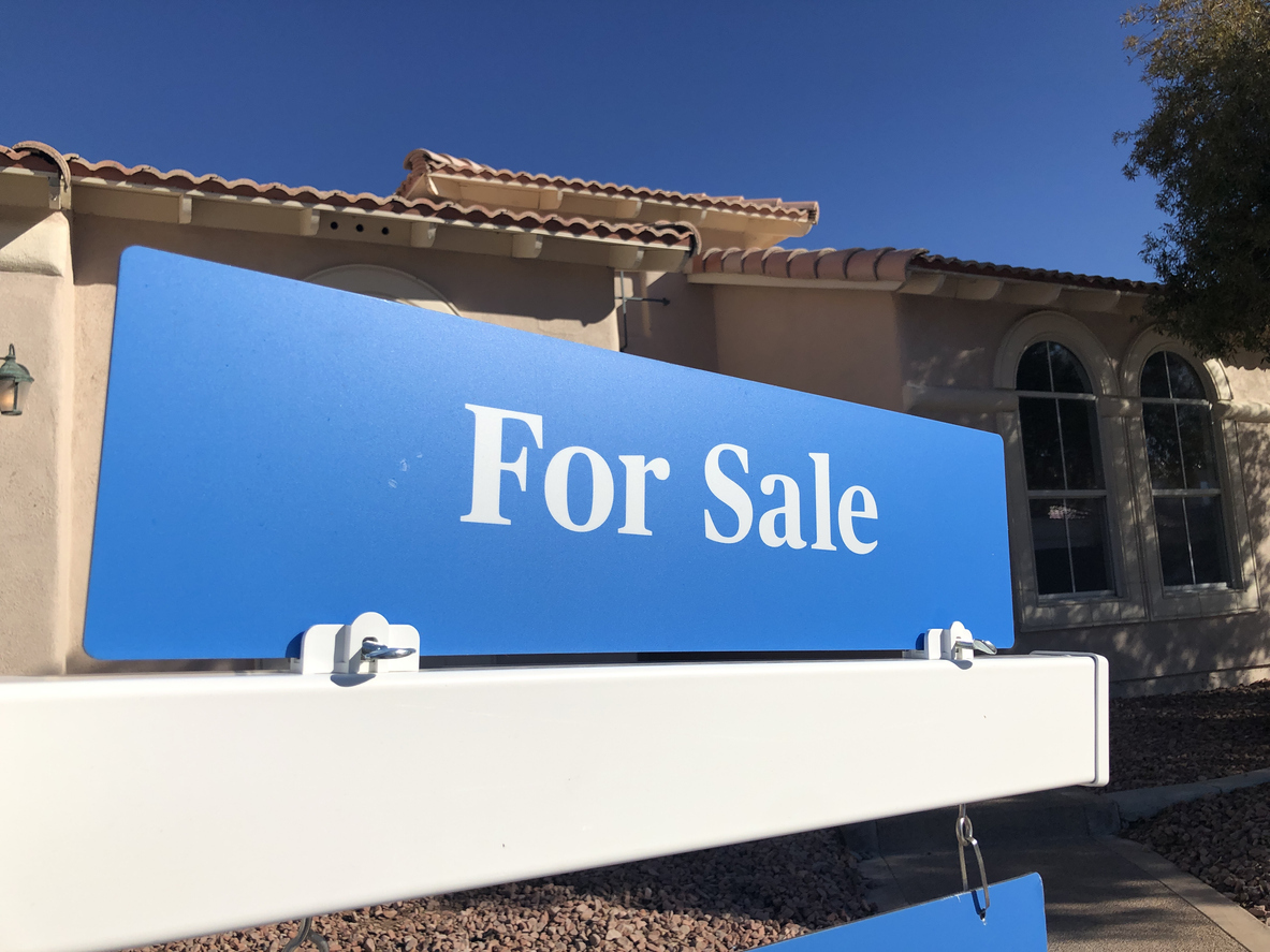 Blue for sale sign in front of house