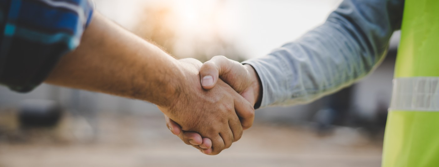 Two builders shaking hands on a jobsite
